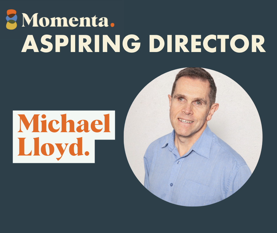 Profile picture of Michael Lloyd. Michael wears a light blue shirt and is smiling. Text above photo reads Momenta Aspiring Director Michael Lloyd.